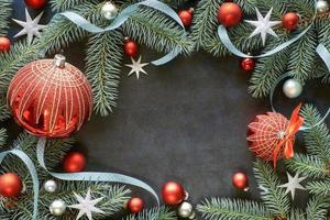 kerstlijst met dennentakjes, snuisterijen in rood en zilver, sterren en linten