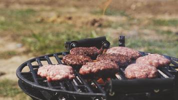 buiten barbecue voorbereiding in gietijzeren rooster met een authentieke ijzeren houtskoolgrill. selectieve focus met ondiepe scherptediepte. roken bbq met verse gehaktballen. foto