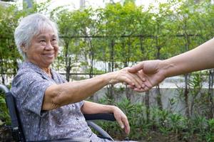 hand in hand Aziatische senior of oudere oude dame vrouw patiënt met liefde, zorg, aanmoediging en empathie in het park. foto