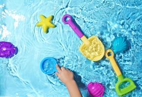 kinderpret met strandspeelgoed op opspattend water foto