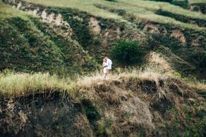 een man met een meisje in lichte kleding op de achtergrond van een groene canyon foto