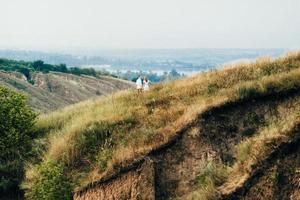 een man met een meisje in lichte kleding op de achtergrond van een groene canyon foto