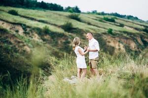 een man met een meisje in lichte kleding op de achtergrond van een groene canyon foto