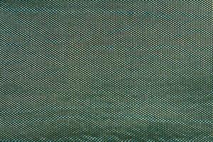 het abstracte oppervlak van de geweven stof in groen voor een achtergrondpatroon. een gedetailleerde grafische element voor een creatief ontwerp. foto