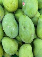 groep mango op de plank van het supermarktdisplay. fruit boodschappen doen. een display voor natuur achtergrond. foto