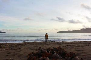 Indonesië 2021. een stel dat op het strand speelt bij zonsondergang foto