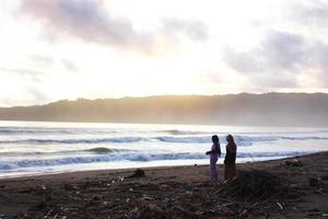 Indonesië 2021. een stel dat op het strand speelt bij zonsondergang foto