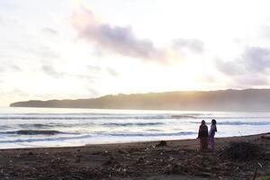 Indonesië 2021. een stel dat op het strand speelt bij zonsondergang foto