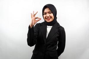 Mooie jonge Aziatische moslim zakenvrouw glimlachend zelfverzekerd, enthousiast en vrolijk met handen ok teken, succes, goed werk, succes teken, geïsoleerd op een witte achtergrond foto