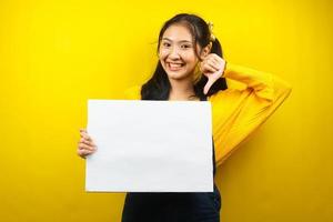 mooie en schattige jonge vrouw vrolijk met lege lege banner, plakkaat, wit bord, leeg bord, wit reclamebord, iets presenteren in kopieerruimte, promotie foto