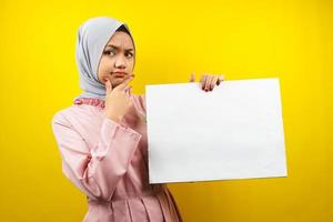 mooie jonge moslimvrouw denken, hand met lege lege banner, plakkaat, wit bord, leeg bord, wit reclamebord, iets presenteren in kopieerruimte, promotie foto