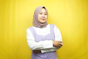 mooie jonge aziatische moslimvrouw die vol vertrouwen lacht met uitgestrekte armen naar de camera gericht geïsoleerd op gele achtergrond foto
