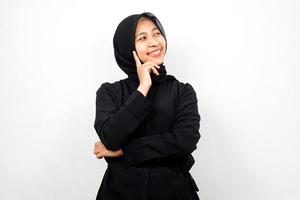 Mooie en vrolijke jonge Aziatische moslimvrouw, kijkend naar lege ruimte, iets presenteren, geïsoleerd op een witte achtergrond foto