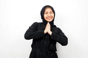 mooie en vrolijke jonge Aziatische moslimvrouw, handen op het gezicht, geïsoleerd op een witte achtergrond foto