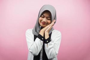 mooie aziatische jonge moslimvrouw die vredig slaapt, zich comfortabel voelt, zich gelukkig voelt, geïsoleerd op roze achtergrond