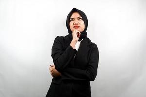 Mooie Aziatische jonge moslim zakenvrouw denken, op zoek naar ideeën, op zoek naar oplossingen voor problemen, met handen met kin, geïsoleerd op een witte achtergrond foto