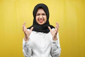 Mooie jonge Aziatische moslimvrouw geschokt, duizelig, gestrest, ongelukkig, veel problemen, wil oplossing, met handen omhoog geïsoleerd op gele achtergrond foto