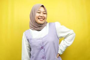 mooie jonge aziatische moslimvrouw die vol vertrouwen lacht met uitgestrekte armen naar de camera gericht geïsoleerd op gele achtergrond foto