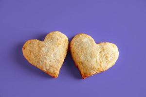 hartvormige koekjes voor Valentijnsdag op paarse achtergrond. trendy kleur van het jaar 2022. foto