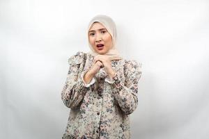Mooie jonge Aziatische moslimvrouw verdrietig, geschokt, verrast, wow uitdrukking, met gevouwen handen, geïsoleerd op een witte achtergrond foto