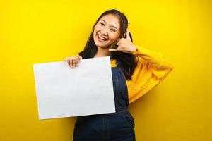 mooie en schattige jonge vrouw vrolijk met lege lege banner, plakkaat, wit bord, leeg bord, wit reclamebord, iets presenteren in kopieerruimte, promotie foto