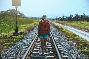 aziatische vrouwen reizen door het platteland. reizen ontspannen. tas rugzak reizen. over de spoorlijn lopen. Thailand foto