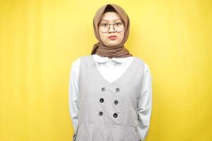 Mooie Aziatische jonge moslimvrouw pruilen, teleurgesteld, ongelukkig, ontevreden, geïsoleerd op gele achtergrond