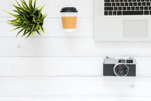 minimale werkruimte - creatieve platliggende foto van werkruimtebureau. bovenaanzicht bureau met laptop en koffiekopje op houten achtergrond.