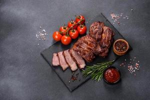 gegrilde biefstukken met kruiden op een donkere snijplank foto