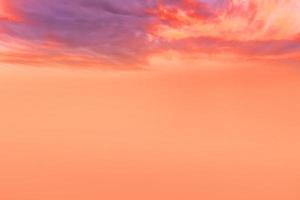 zonsondergang en oranje wolk en blauwe dageraad hemel met wolk horizontale lijnen bewegingseffect op de achtergrond van de zon. foto