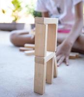 kinderen spelen met houten blokken op de betonnen vloer foto