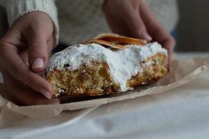 de handen van een vrouw houden een kerstcake met poedersuiker vast. nieuwjaar en kerst. detailopname. foto