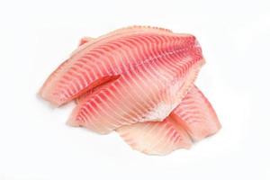 Rauwe tilapia filet vis geïsoleerd op een witte achtergrond voor het koken van voedsel - verse visfilet gesneden voor steak of salade foto