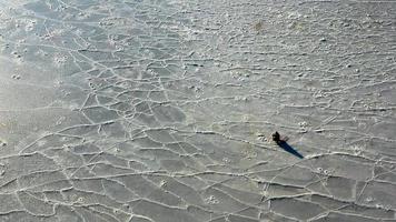 luchtfoto van het ijzige oppervlak van de zee met een visser