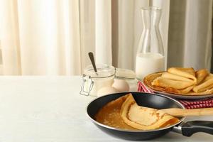 concept van lekker ontbijt met dunne pannenkoeken op witte houten tafel