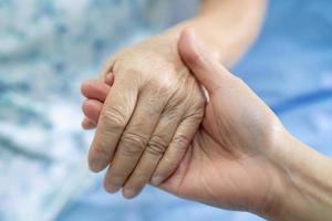 hand in hand aziatische senior of oudere oude dame vrouw patiënt met liefde, zorg, aanmoediging en empathie op verpleegafdeling ziekenhuis, gezond sterk medisch concept foto