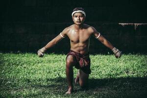 een bokser bond een touw in zijn hand en voerde een gevecht uit, de vechtsporten van muay thai. foto