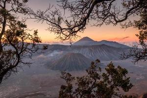 berg vulkaan een actief met boomframe bij zonsopgang foto