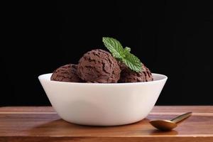chocolade-ijs in witte kom op snijplank foto