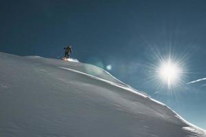 een extreme skiër pakt een verse sneeuwhelling aan foto