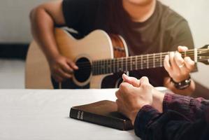 jonge christenen bidden met woorden en zingen lofzangen voor god die de Schriften leest en evangelie deelt met kopieerruimte foto