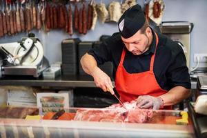 slager die verse ham uitbent in een moderne slagerij foto