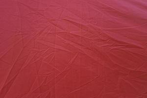gerimpeld rood canvas. rode gestructureerde achtergrond. rode canvas abstracte achtergrond foto