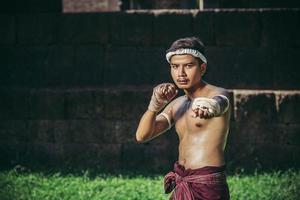 een bokser bond een touw in zijn hand en voerde een gevecht uit, de vechtsporten van muay thai. foto