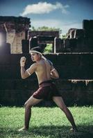 een bokser bond een touw in zijn hand en voerde een gevecht uit, de vechtsporten van muay thai. foto