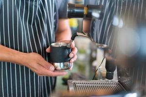 barista melk maken voor koffie latte of cappuccino foto