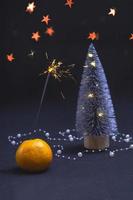 mandarijn, kerstboom en wonderkaarsen op een zwarte achtergrond. banner briefkaart uitnodiging concept. met kopie space.vertical foto