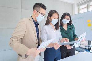 zakelijke werknemers die tijdens het werk op kantoor een masker dragen om de hygiëne te behouden, volgen het bedrijfsbeleid. preventief tijdens de periode van epidemie van coronavirus of covid19.