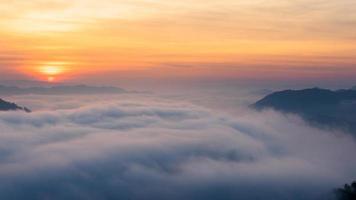 panoramisch uitzicht op verbazingwekkende mist die over de natuurbergen beweegt tijdens zonsopgang in het bergengebied in thailand. foto