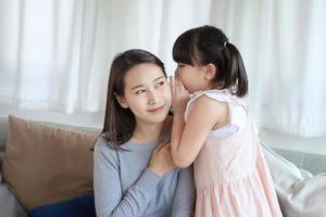 Aziatische moeder voelt geluk tijdens het spelen van haar schattige dochter met liefde en zorg thuis